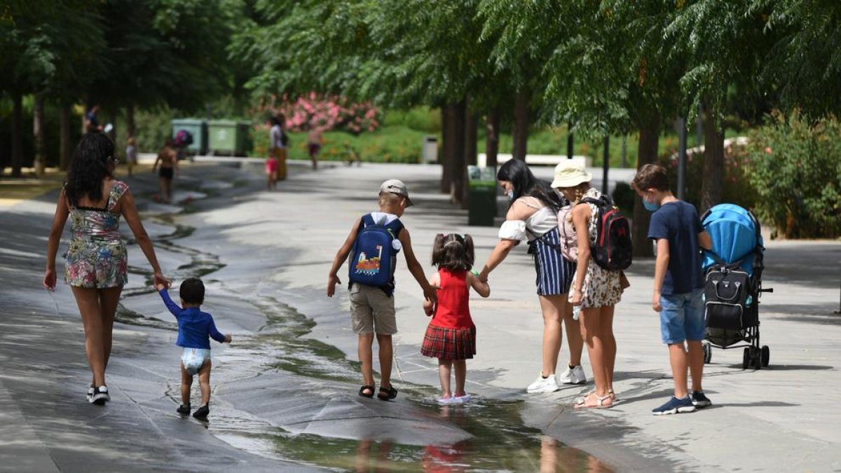 Diversos nens passen per un rierol d'aigua en el Parc Central, a 12 d'agost de 2021, a València, Comunitat Valenciana (Espanya).