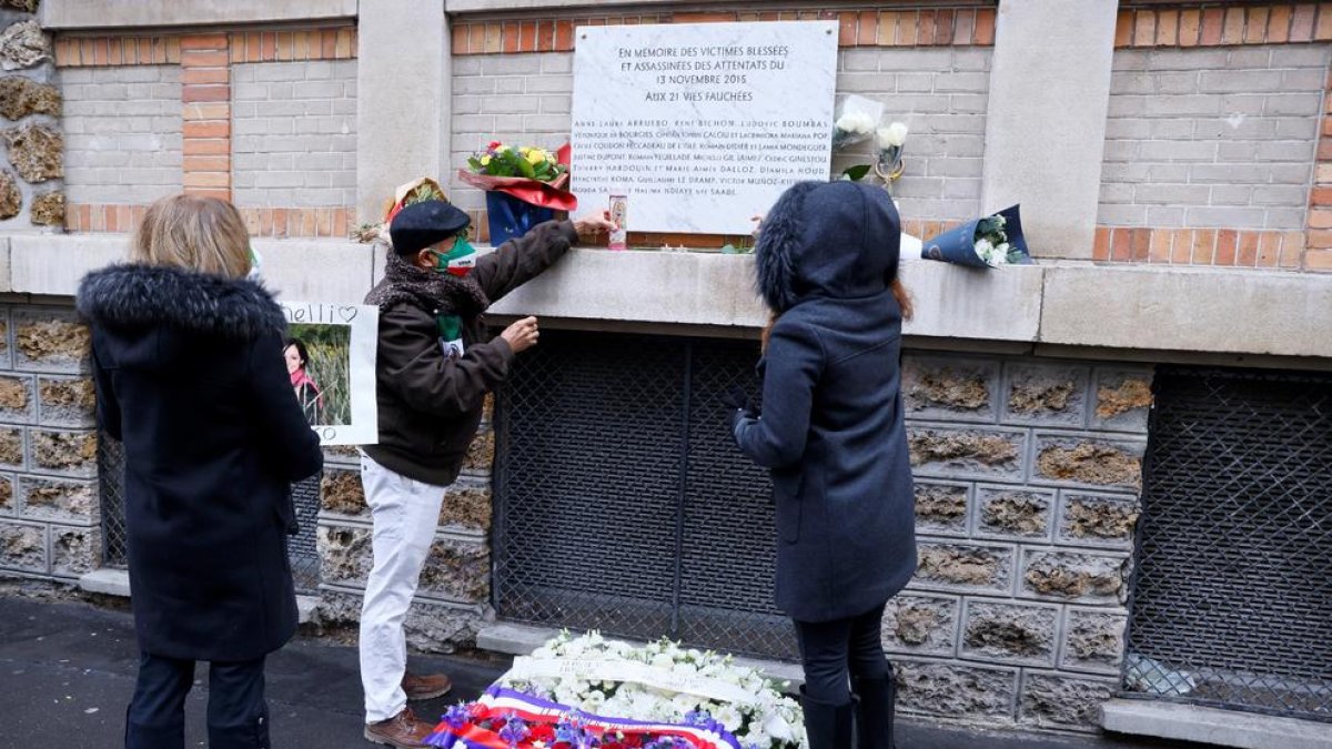 Diverses persones dipositen flors a la façana de la sala Bataclan.