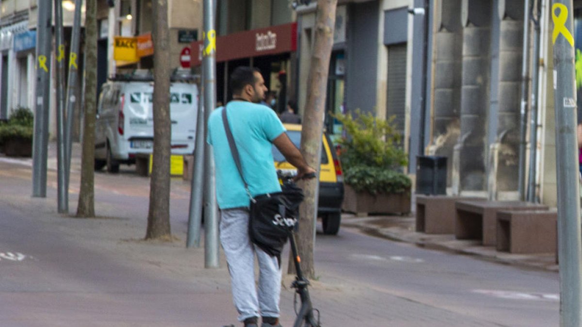 Un conductor con su patinete eléctrico cruzando la avenida Catalunya de la capital del Urgell.