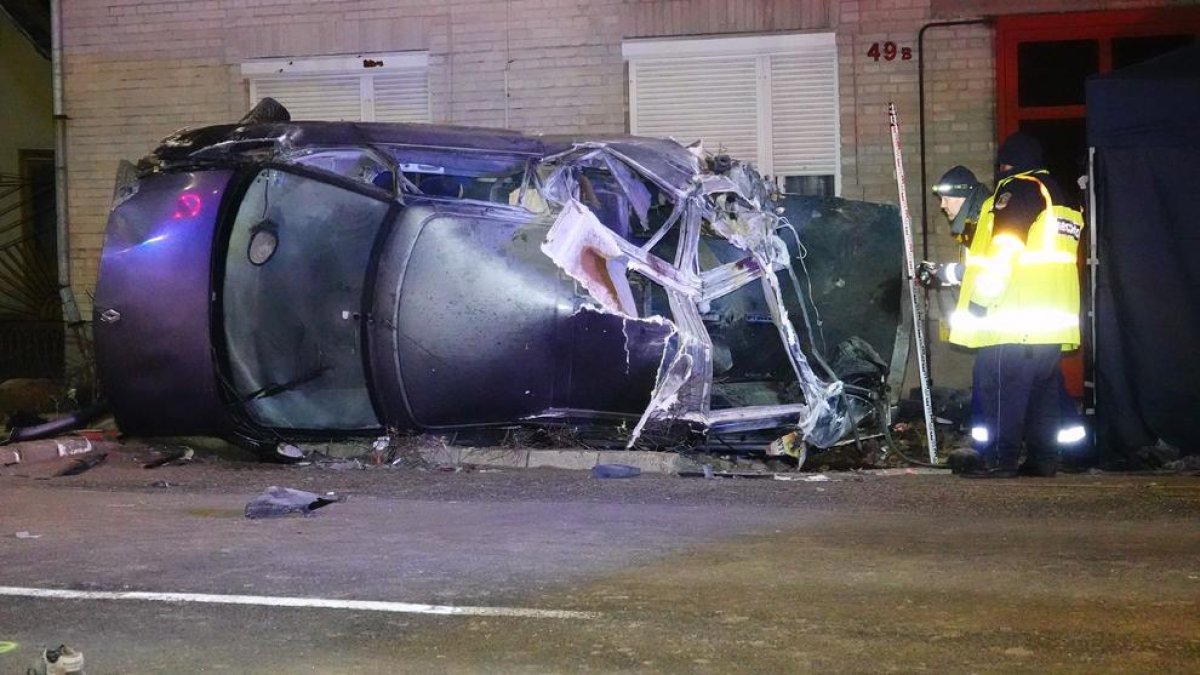 Dos agents inspeccionen l’automòbil després de l’impacte.