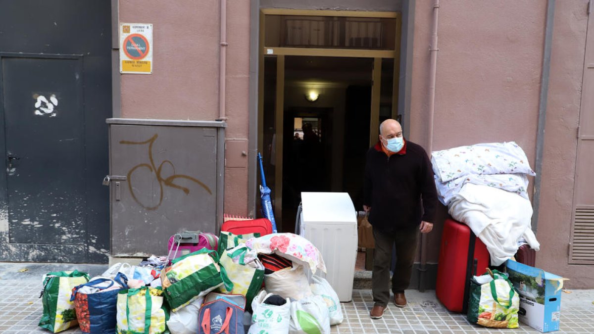 Jordi Massana junto a los enseres de los okupas en la entrada de su vivienda, en la calle Mossèn Reig.