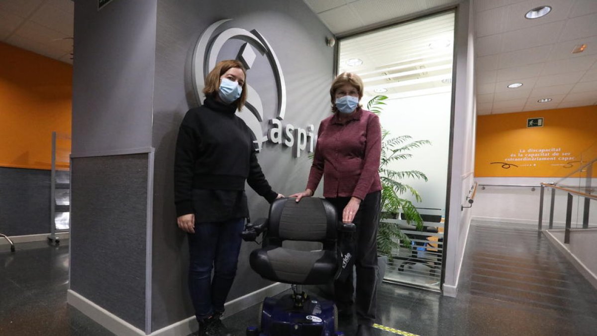 La sòcia d’Aspid Pilar Gasol (dreta), entregant una cadira de rodes motoritzada al banc de material solidari de l’entitat.