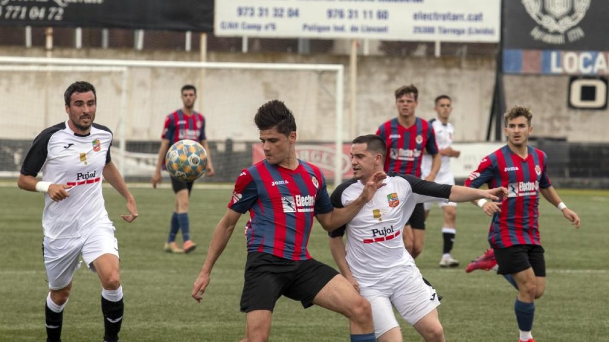 Florica, del Tàrrega, disputa la pilota davant d’un jugador del Borges mentre n’arriba un altre per ajudar-lo.
