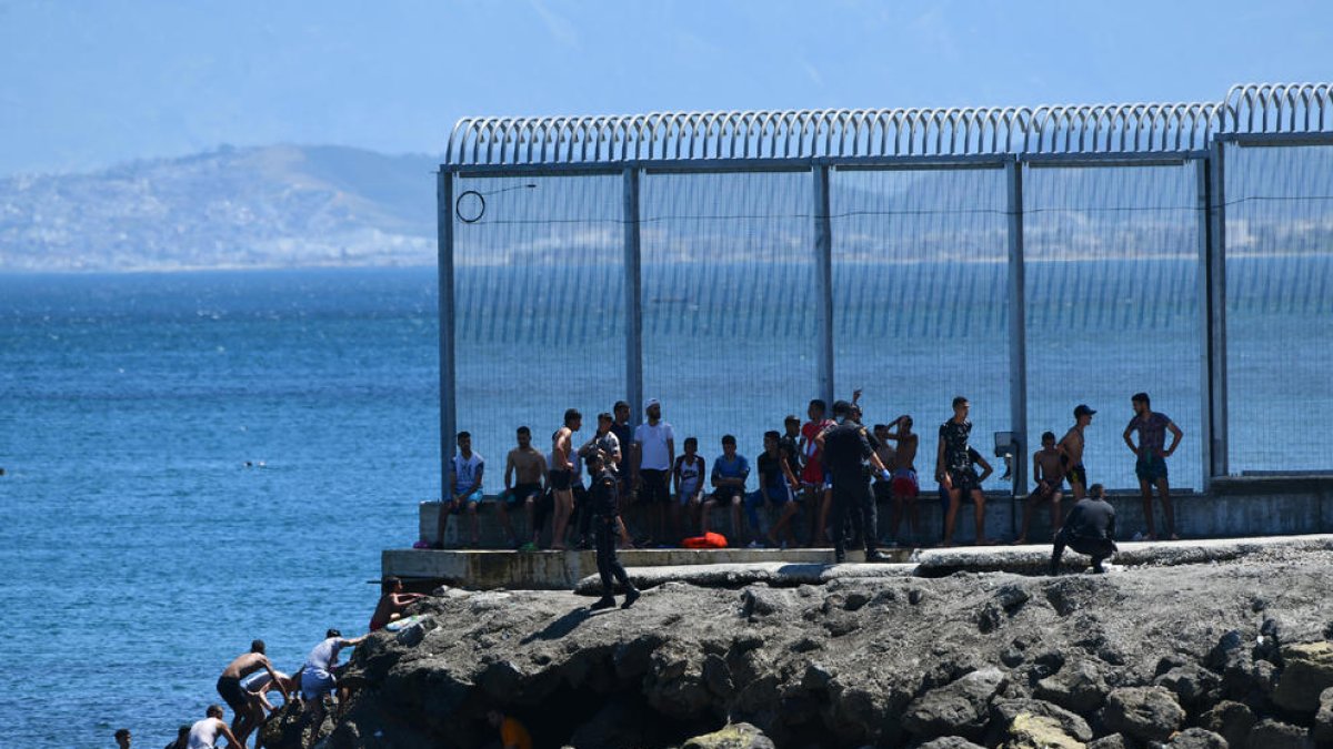 Algunos de los inmigrantes llegados ayer a Ceuta tras atravesar el espigón de Benzú.