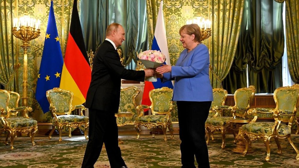 Putin entrega un ram de flors a Merkel, ahir a Moscou.