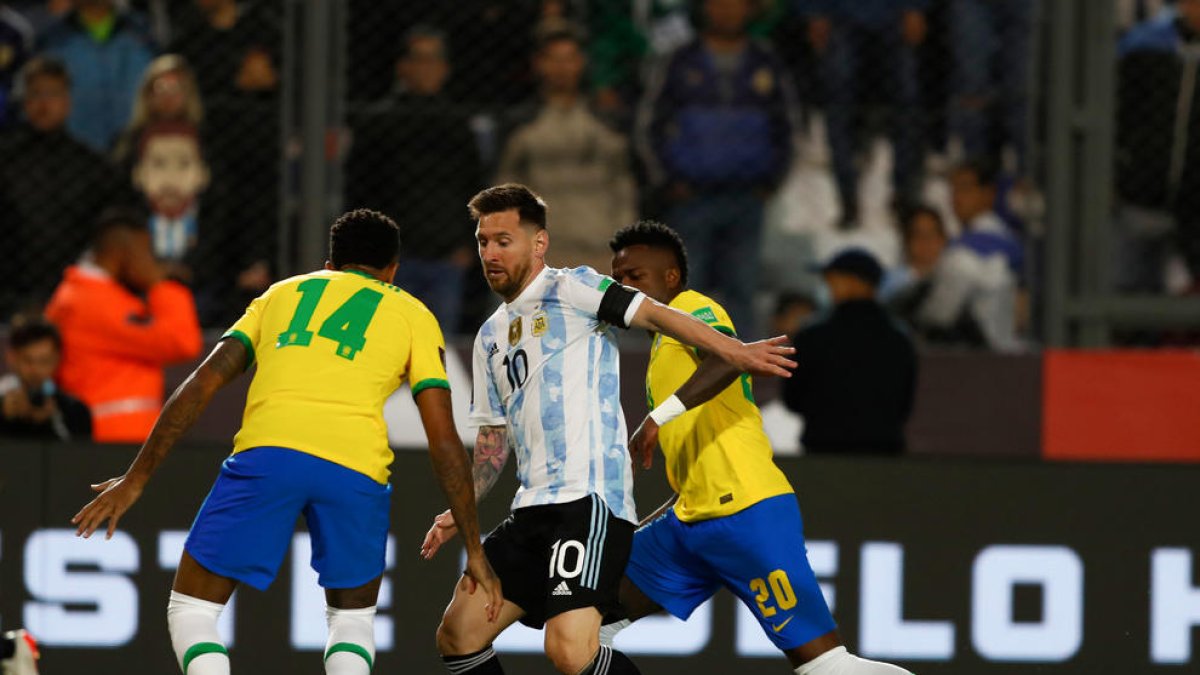 Leo Messi intenta superar a los brasileños Militao y Vinicius.