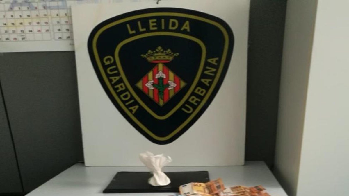 La cocaïna i els bitllets localitzats per la Guàrdia Urbana de Lleida a l'interior d'un vehicle.