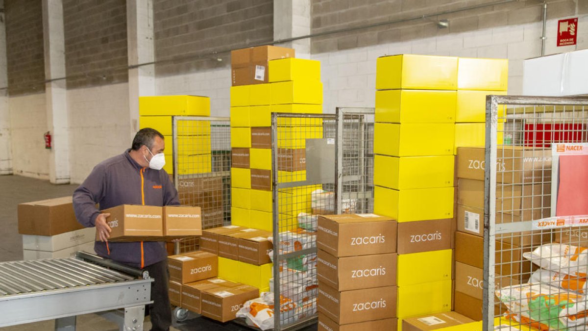 Un trabajador de Nacex Lleida apila unas cajas para llevarlas a una furgoneta y entregarlas, ayer.