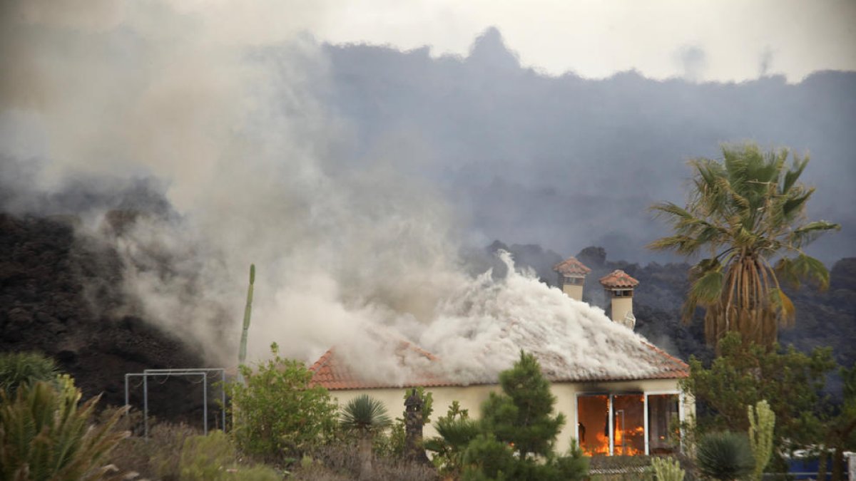Una casa en Los Llanos siendo devorada por las colas de lava que bajan desde Cumbre Vieja, que ya han arrasado más de un centenar.