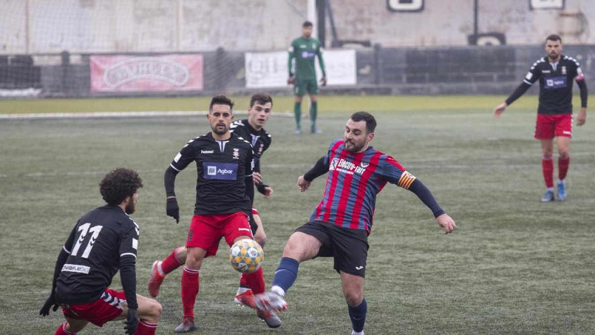 El local Izán pugna con un rival en un balón dividido .