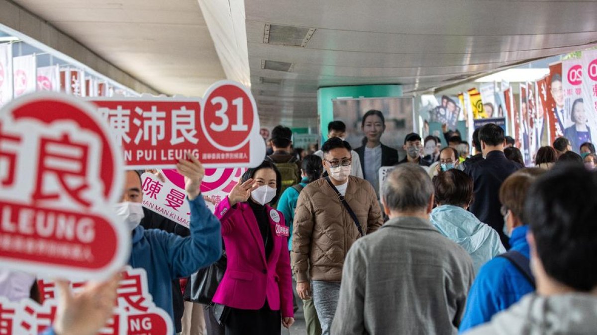 Diversos voluntaris van animar ahir els hongkonguesos a votar.