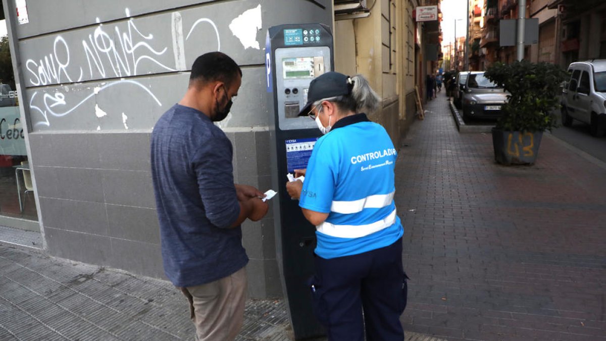 Imagen de una vigilante de parquímetro informando a un usuario.