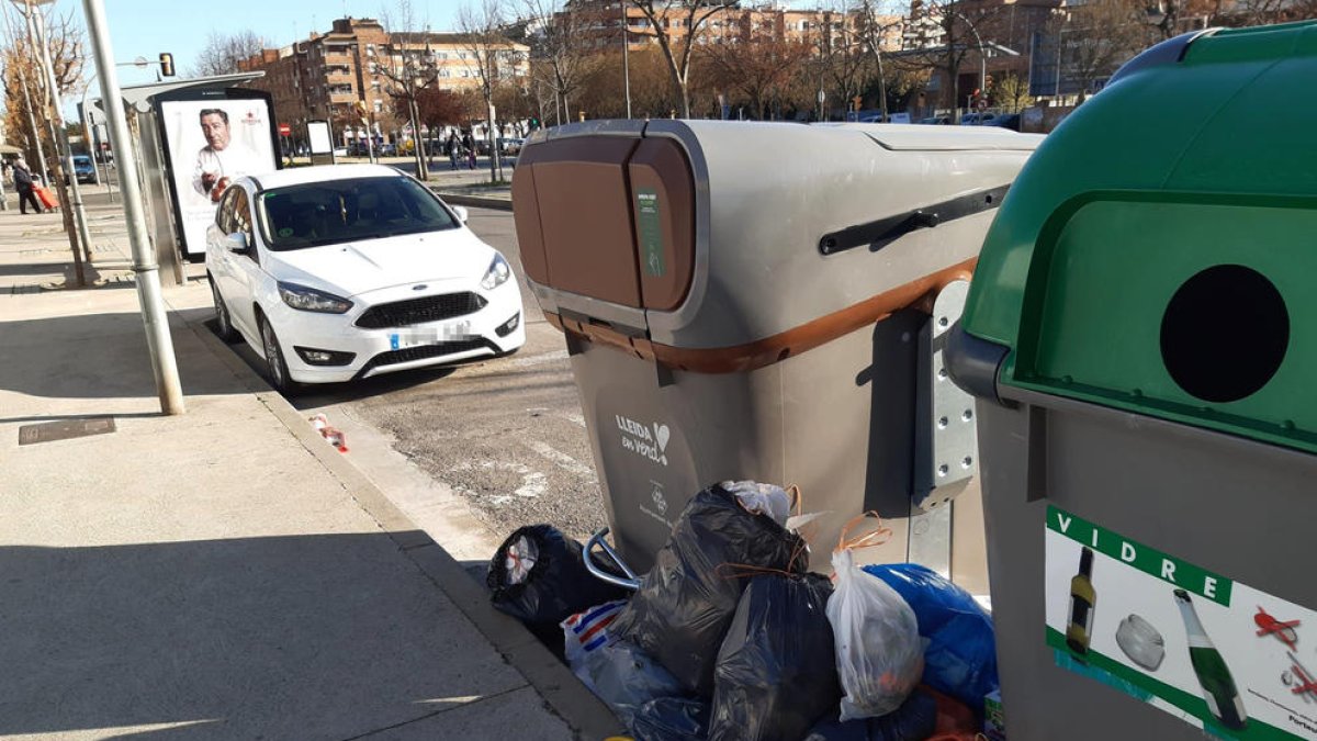 Contenedores, con bolsas de basura fuera.