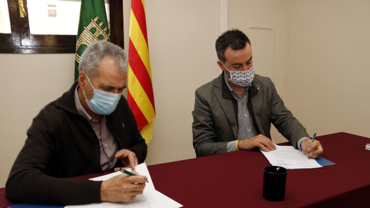 El president de l'ACM, Lluís Soler, i el de l'Associació de Micropobles de Catalunya, Mario Urrea, signant un conveni de col·laboració, a Torrebesses, aquest dijous.