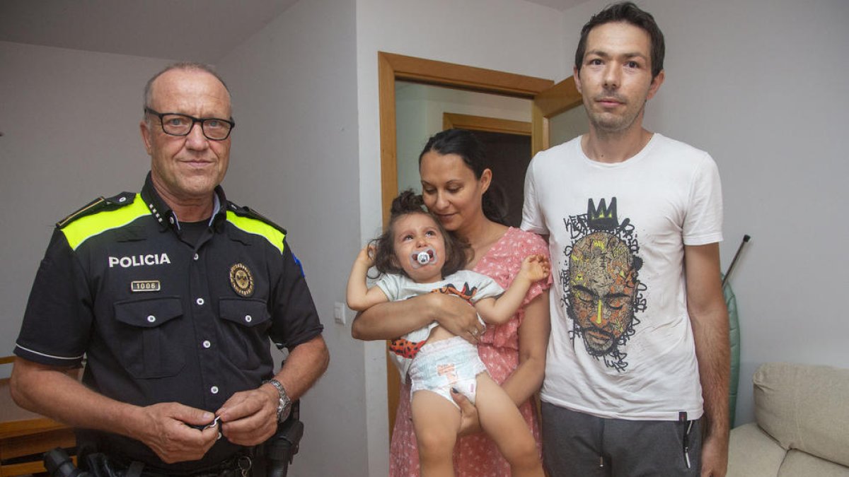 El caporal de la Policia Local de Tàrrega Antoni Gutiérrez al costat de la família i el petit que va salvar ahir al seu habitatge a Tàrrega.