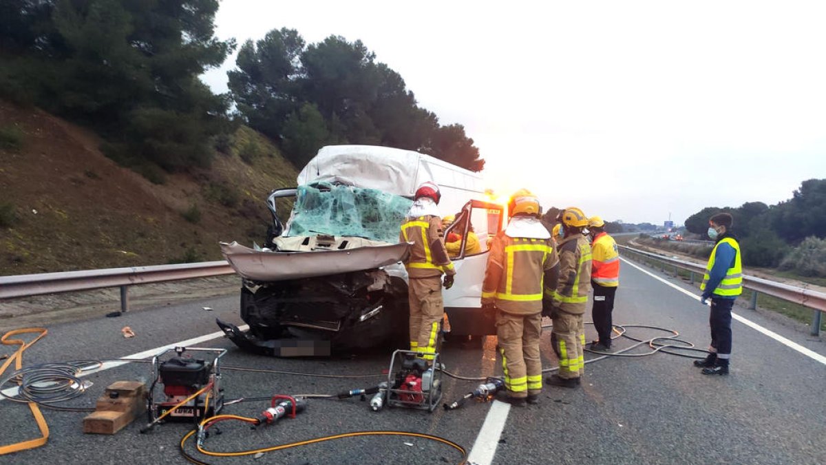 Bombers i sanitaris durant el rescat del conductor ferit.