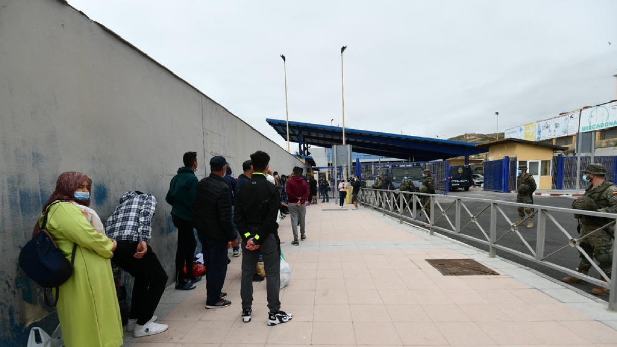 Varios marroquíes hacen cola en la frontera para volver a su país.