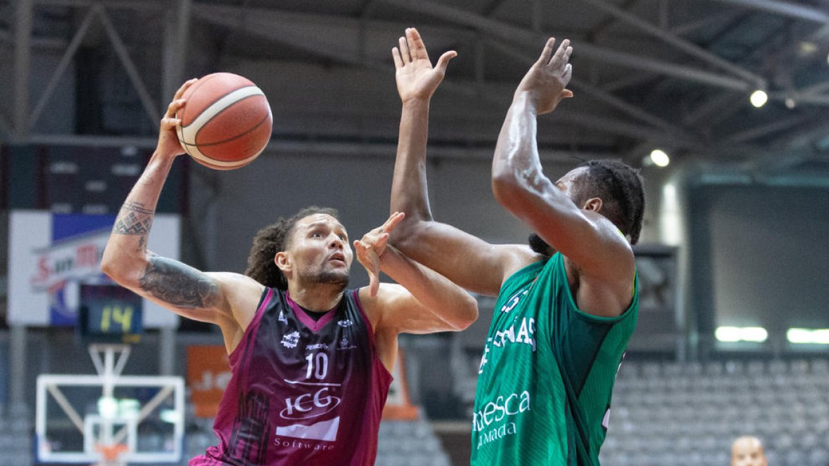 Michael Carrera intenta superar un jugador de l’Osca durant el partit d’ahir.