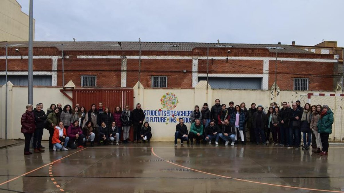 Alumnes i professors de l’institut, al costat del mural col·lectiu a favor de la sostenibilitat.