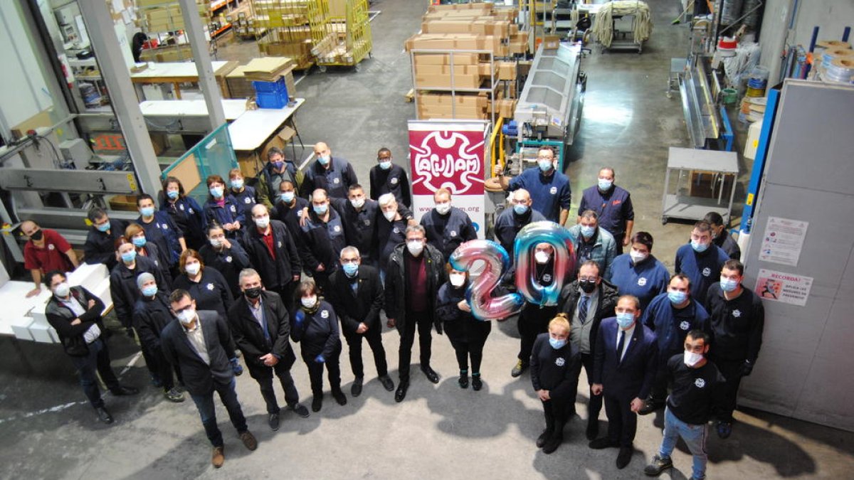 Les autoritats, juntament amb alguns treballadors al taller.