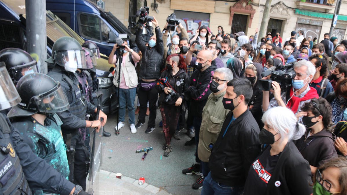 Diputados de la CUP ante la línea de los Mossos, ayer, durante un desahucio en Barcelona.