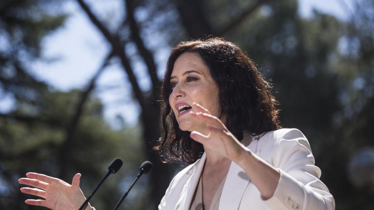 La presidenta madrileña, Isabel Díaz Ayuso, y el candidato del PSOE, Ángel Gabilondo, ayer, en sendos actos de precampaña.