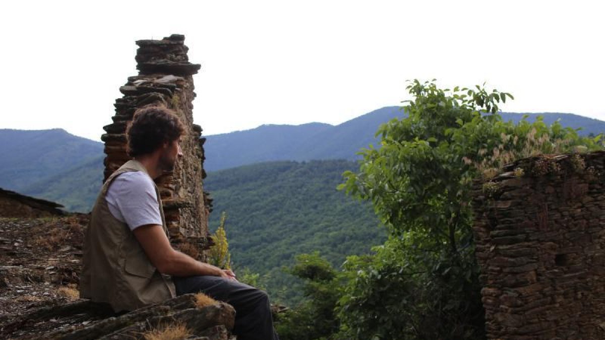 Bruno Oro observa el deterioro de las casas, en medio de bosques.