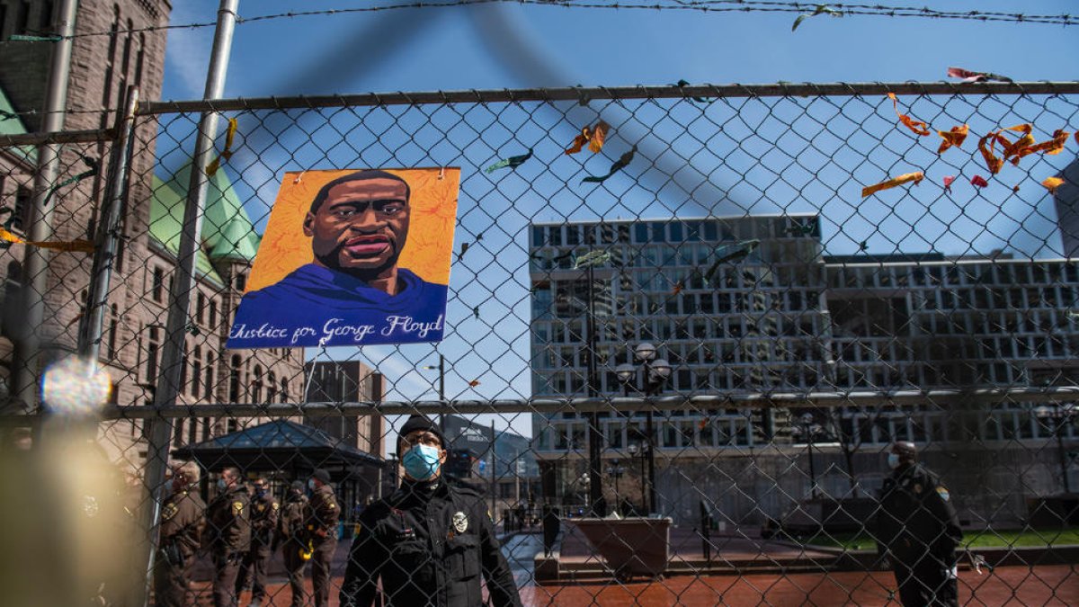 Un policia treu imatges en favor de George Floyd.