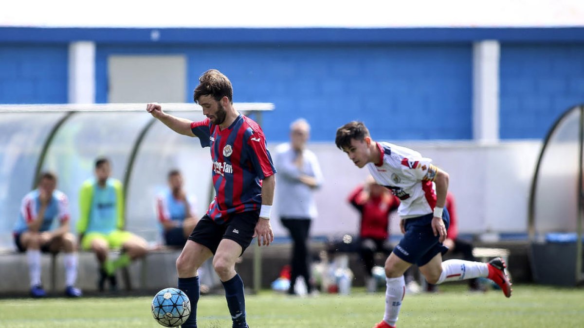 Un jugador del Tàrrega controla el balón ante un defensor del Sant Ildefons.