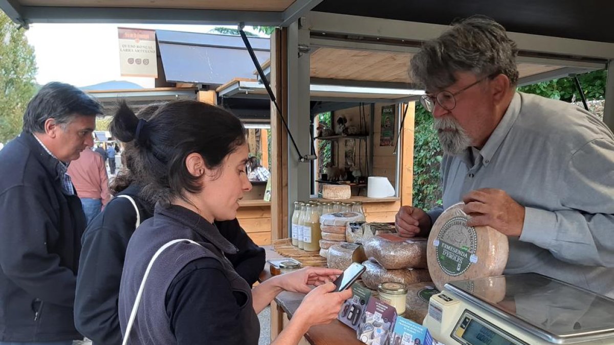Una de las visitantes de la feria utilizando el código QR para conocer los diferentes quesos.