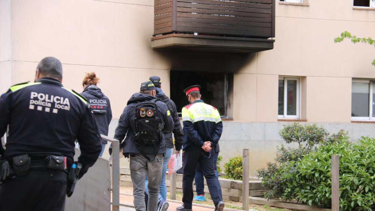 Agentes en el lugar del suceso y, de fondo, una ventana ennegrecida.