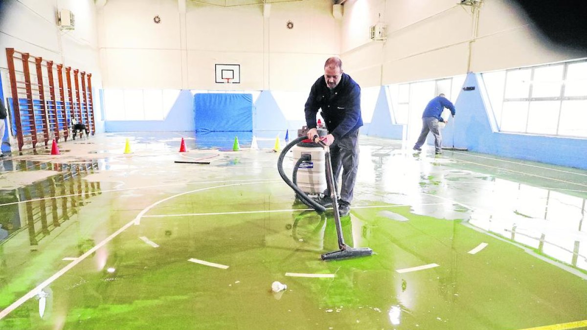 Operarios del ayuntamiento eliminando el agua acumulada del polideportivo.
