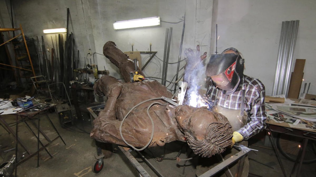 El autor de la escultura, Miquel Ángel González, trabajando ayer en su  restauración.