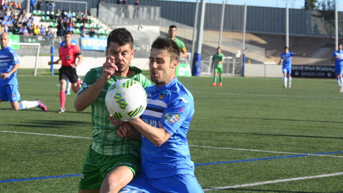 Dos jugadors lluiten per una pilota en una acció del partit d’ahir a Cornellà.