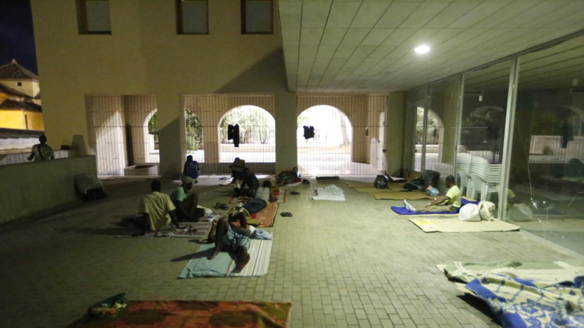 Un grup de temporers dorm al ras al carrer Nou.