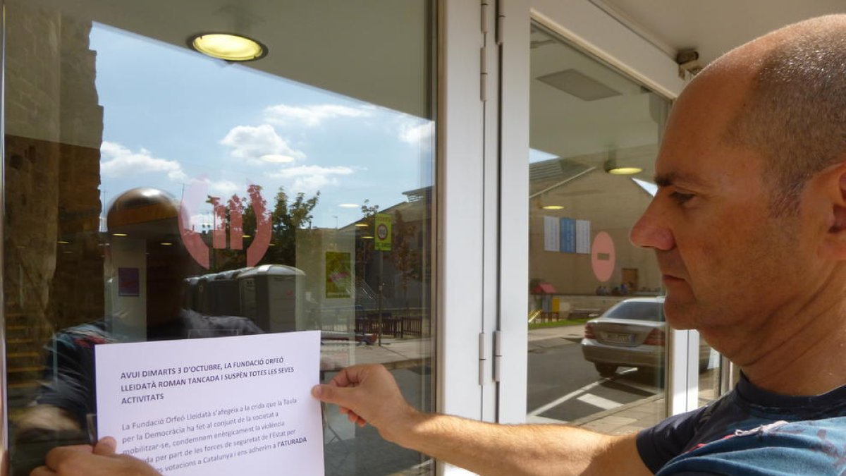 Xavier Quinquillà, pegando ayer el cartel en la puerta del Orfeó Lleidatà anunciando el cierre del centro.