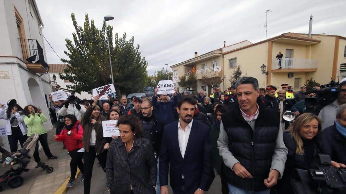 Dolors Montserrat, Dante Pérez, Xavier García Albiol y Marisa Xandri, seguidos por manifestantes y protegidos por mossos.