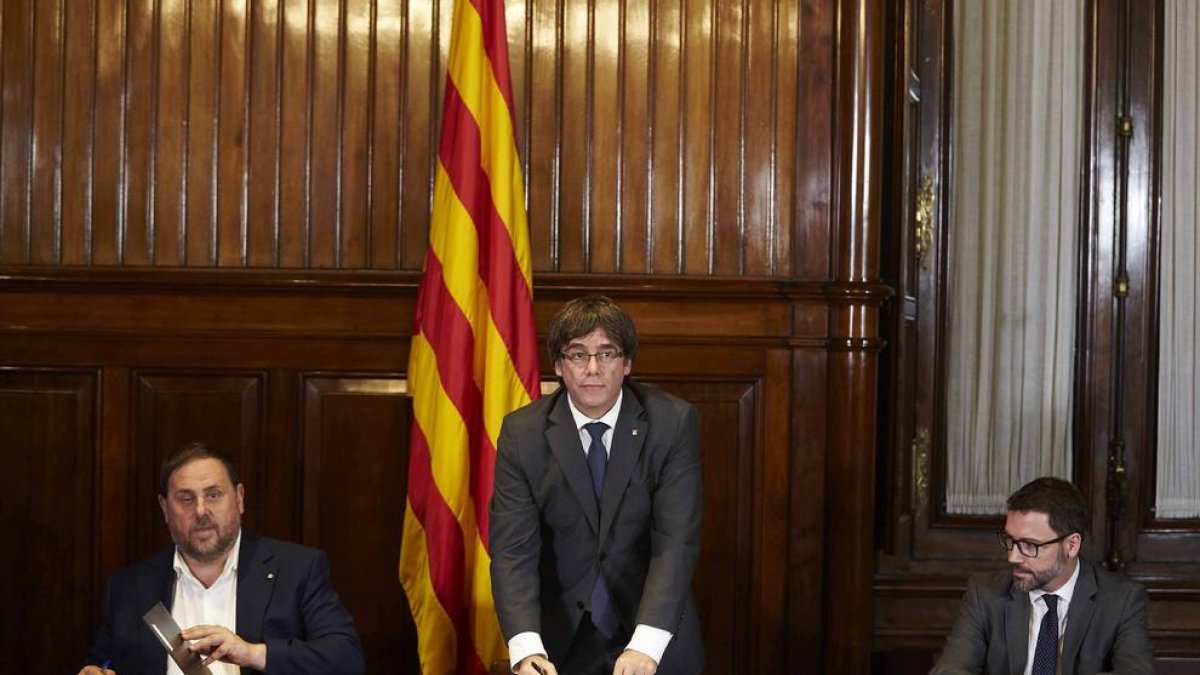 El President, Carles Puigdemont, firma la convocatoria del referéndum junto al vicepresident, Oriol Junqueras.