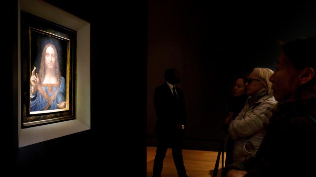 Diverses persones contemplen el quadre ‘Salvator Mundi’, de Leonardo.