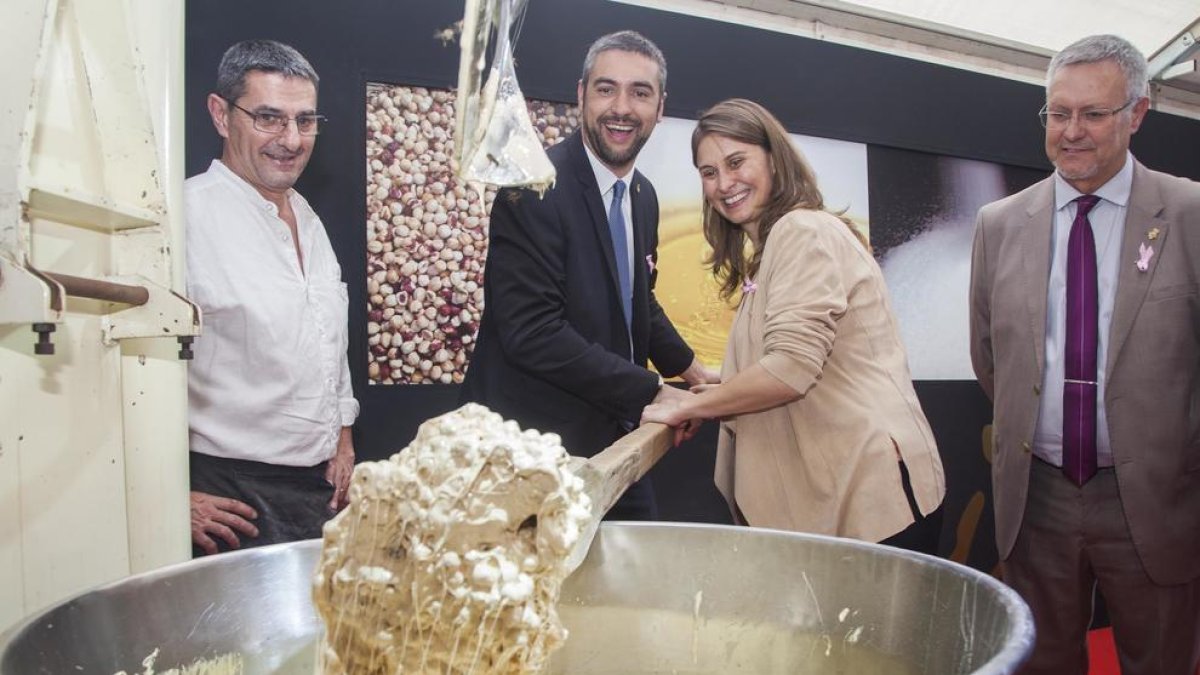 La consellera Meritxell Serret i l’alcalde d’Agramunt, Bernat Solé, barregen ingredients del torró.