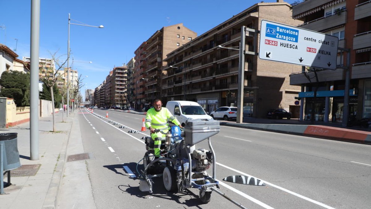 Un operari acaba de pintar la senyalització del nou carril bici, ahir al matí.