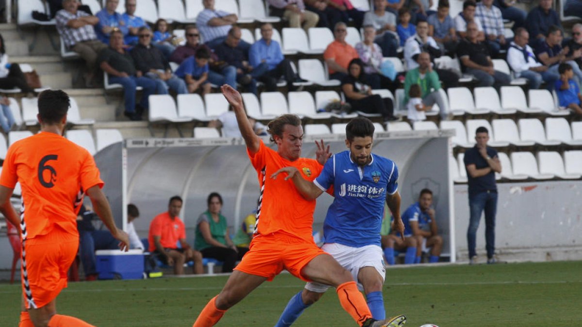 Iván Agudo, que va jugar un partit molt complet, lluita amb un jugador del Llagostera en una acció del partit d’ahir al Camp d’Esports.