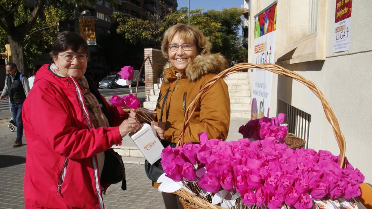 Una mujer colabora ayer con la iniciativa ‘Una flor per a un projecte’ en la mesa de Ricard Viñes.