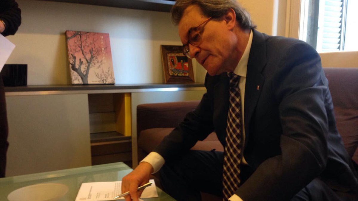 Momento en el que Mas firma la recepción de la sentencia del Superior de Justicia.