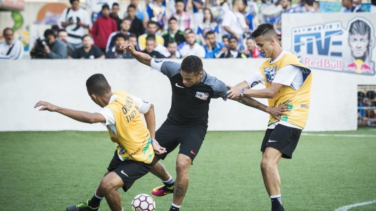 Neymar, en foto de archivo, jugando su propio torneo e intentando regatear a dos rivales.