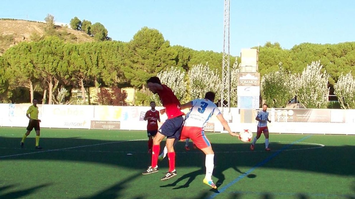 Dos jugadors salten a la disputa d’una pilota al partit entre el Fraga i el Sariñena.