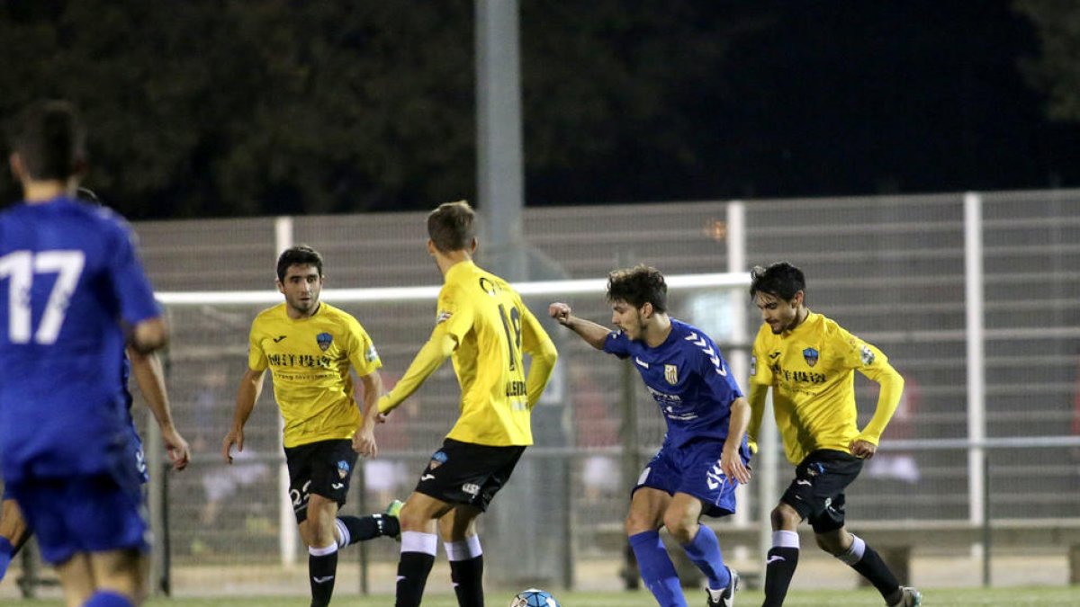 Tres jugadors del Lleida intentaven robar la pilota a un rival.