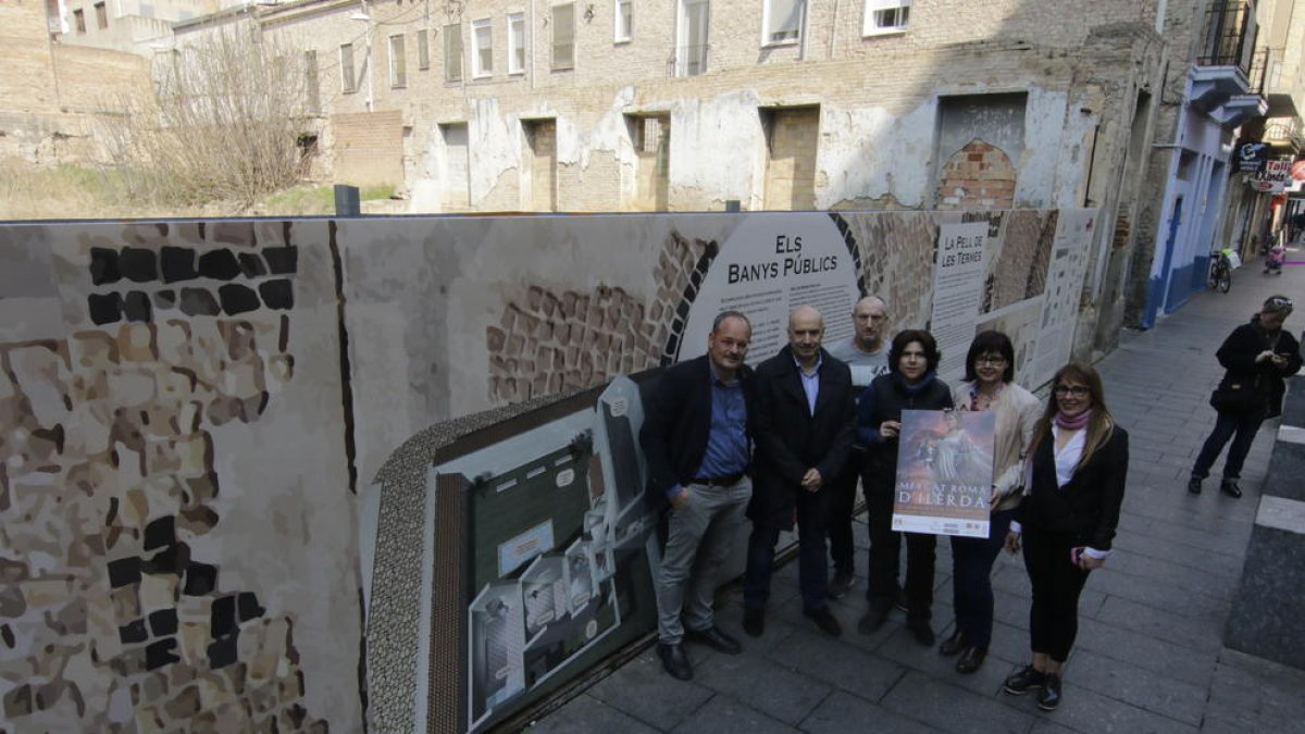 Peris y comerciantes, ante el nuevo mural informativo.