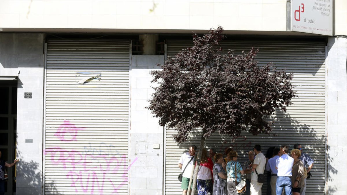 Un grupo de leridanos se refugia en la sombra de un árbol en la avenida de Les Garrigues.