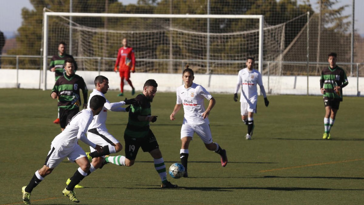 Diversos jugadors locals envolten el visitant Cervantes, en una de les jugades del partit que va enfrontar el Borges contra el Sants.